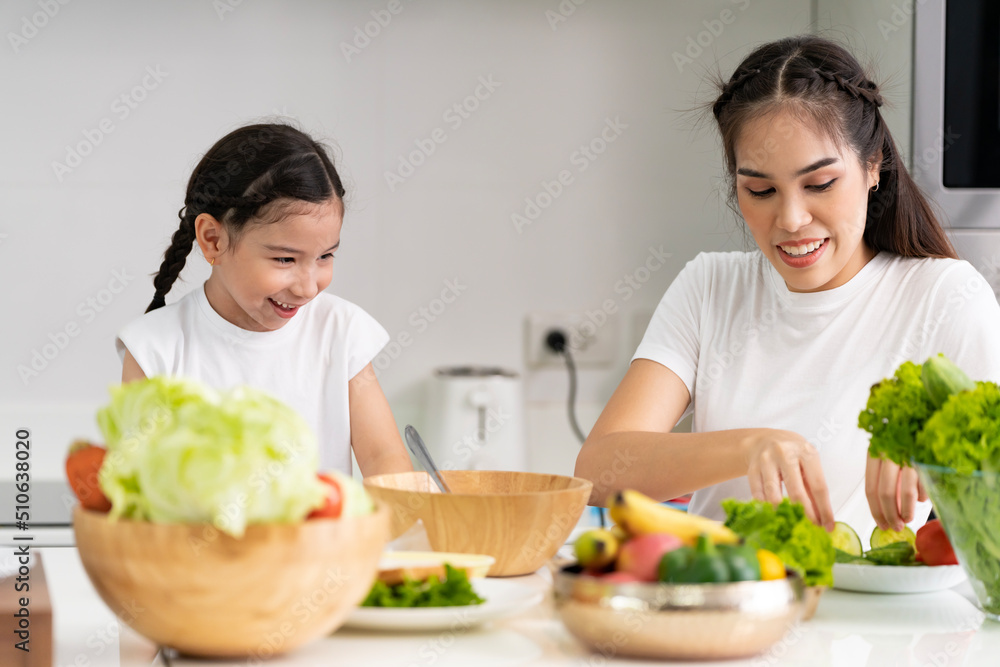Asian girl learning to cook with her mother. Do activities together with your family in a fun and joyful way. There is a mother who takes care of closely