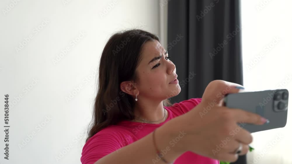 Pretty teenage girl recording dance video on modern smartphone camera in living room. Female student or teenager dancing for social network. Young smiling blogger making music content for channel. 4k Pretty teenage girl recording dance video on modern smartphone camera in living room. Female student or teenager dancing for social network. Young smiling blogger making music content for channel. 4k