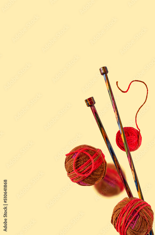 balls of thread and knitting wooden needles on a yellow background, selective focus, copy space balls of thread and knitting wooden needles on a yellow background, selective focus, copy space