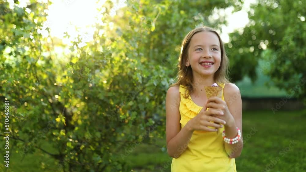 Happy girl with braces eating italian ice cream cone smiling while resting in park on summer day, child enjoying ice cream outdoor, happy holidays, summertime Happy girl with braces eating italian ice cream cone smiling while resting in park on summer day, child enjoying ice cream outdoor, happy holidays, summertime