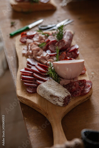Cutting board with variety of typical Italian cold cuts and meats placed on the preparation table during a catering event