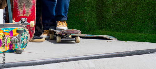 Unrecognizable young person at the skatepark read to ride and make a stunt. Urban lifestyle, summer vacations and eisure activities concept. photo