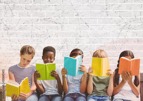 Group of diverse students reading books against grey brick wall background with copy space