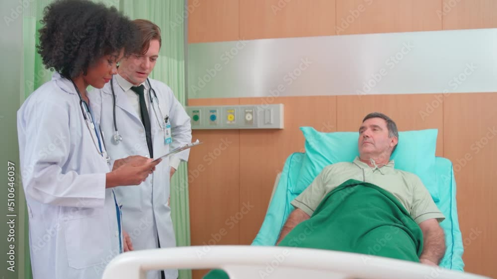 Doctor man and woman discuss and explain to senior patient who lie on bed during treatment process and the patient stay in hospital care room. Doctor man and woman discuss and explain to senior patient who lie on bed during treatment process and the patient stay in hospital care room.