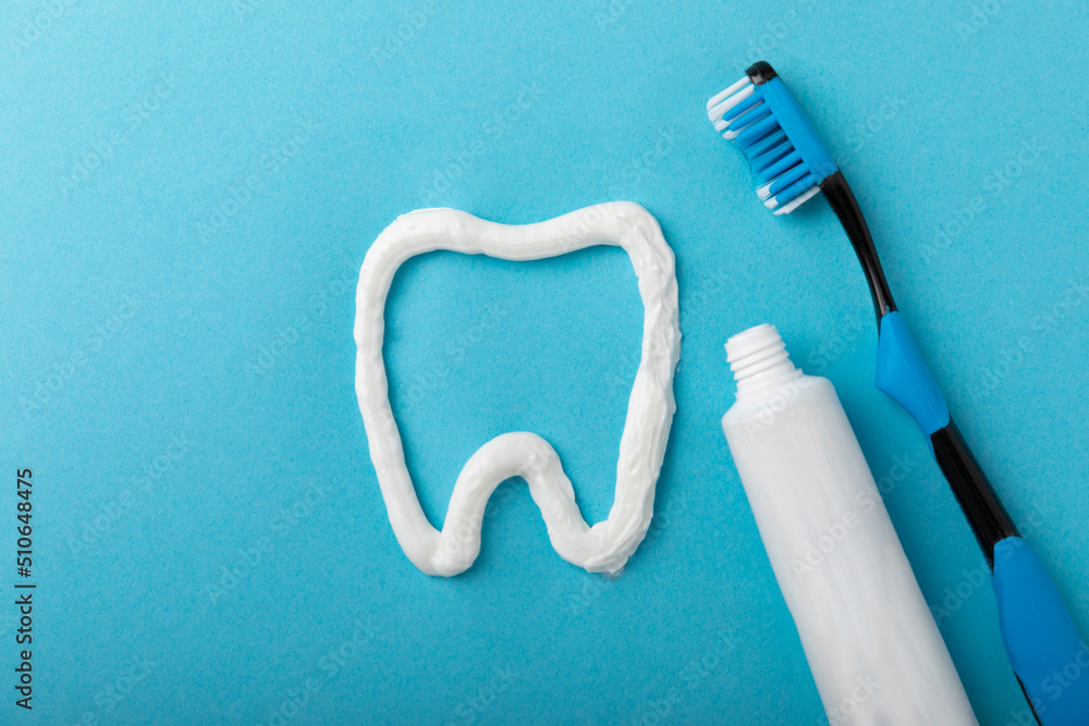 Toothpaste Copy Tooth symbol made from toothpaste and a toothbrush on a blue background ...