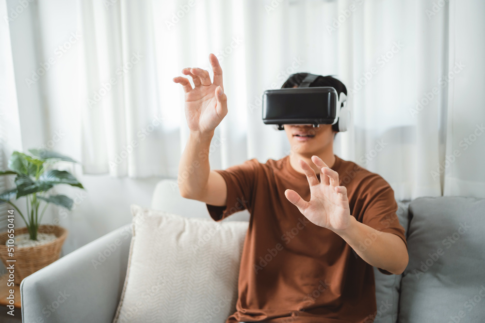 Asian man using VR headset in glasses of virtual reality technology VR experience Future technology Asian man using VR headset in glasses of virtual reality technology VR experience Future technology