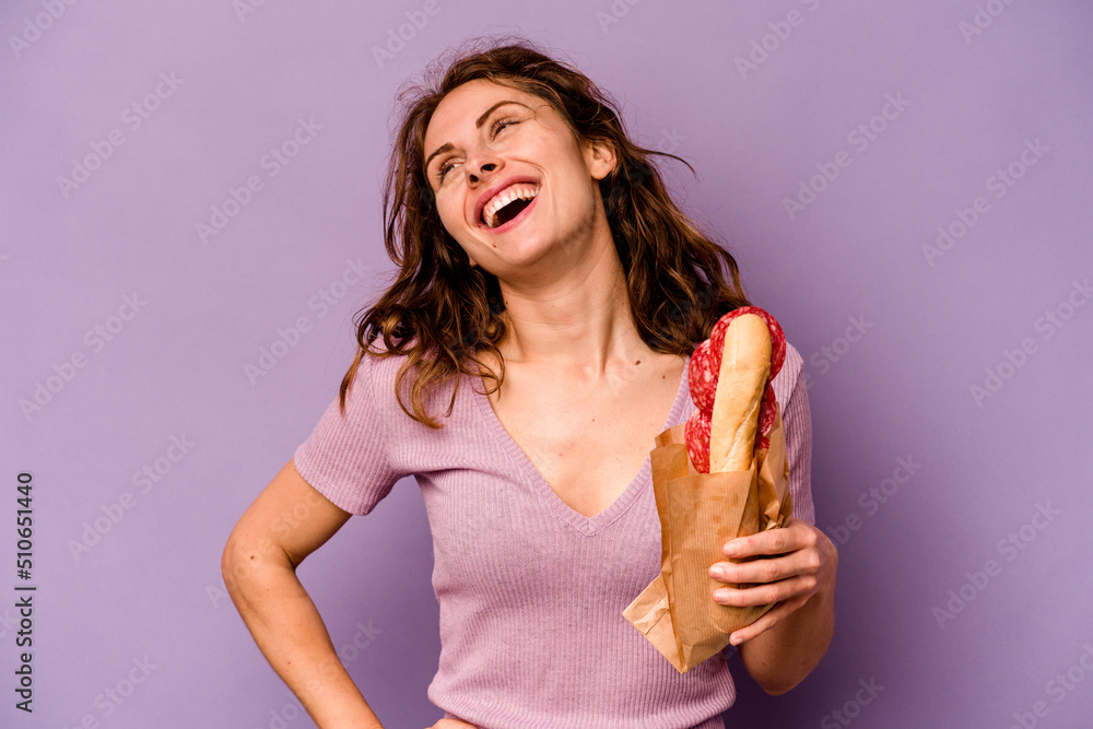 Young caucasian woman eating a sandwich isolated on purple background dreaming of achieving goals and purposes Young caucasian woman eating a sandwich isolated on purple background dreaming of achieving goals and purposes