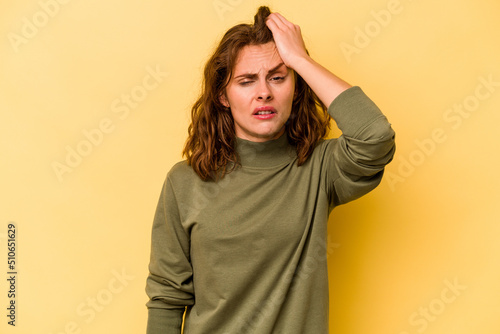Young caucasian woman isolated on yellow background tired and very sleepy keeping hand on head. © Asier