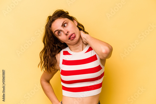 Young caucasian woman isolated on yellow background suffering neck pain due to sedentary lifestyle.