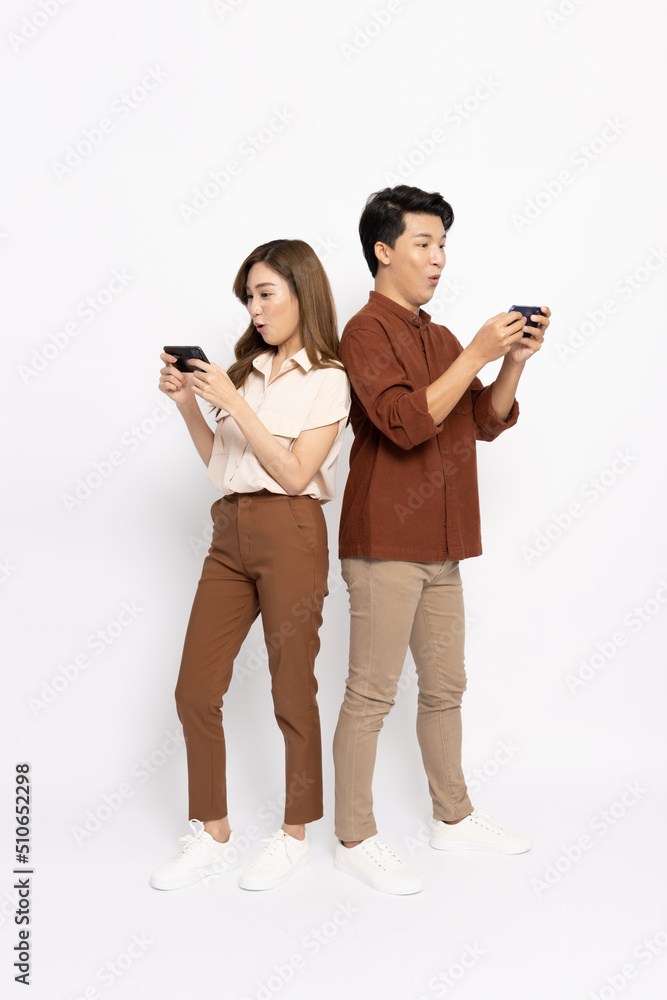 Portrait of young smiling Asian couple using mobile phone with application isolated on white background, Asian Thai model Portrait of young smiling Asian couple using mobile phone with application isolated on white background, Asian Thai model