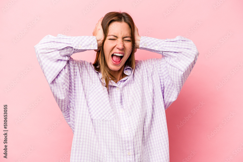 Young caucasian pregnant woman isolated on white background covering ears with hands trying not to hear too loud sound. Young caucasian pregnant woman isolated on white background covering ears with hands trying not to hear too loud sound.