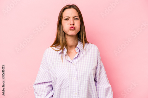 Young caucasian pregnant woman isolated on white background blows cheeks, has tired expression. Facial expression concept.