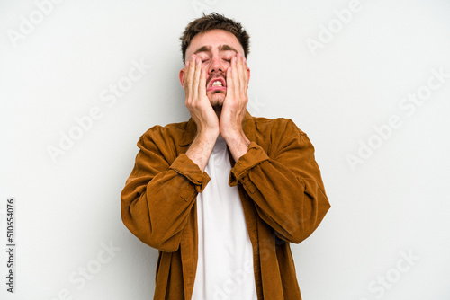 Young caucasian man isolated on white background whining and crying disconsolately.