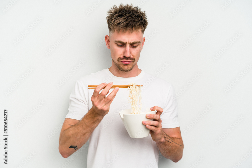 Young caucasian man eating noodles isolated on white background Young caucasian man eating noodles isolated on white background