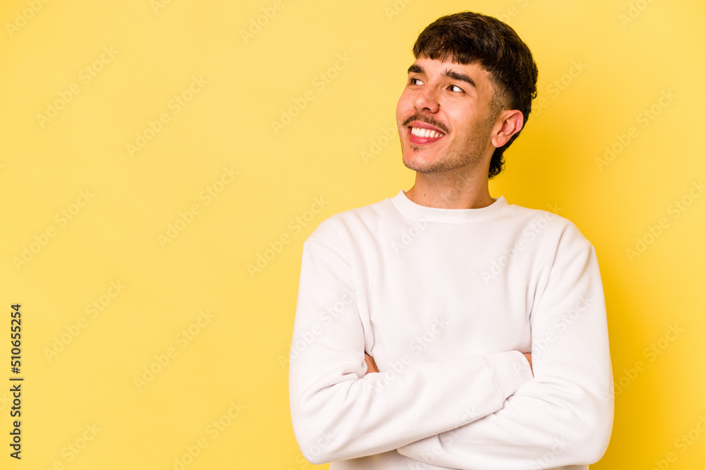 Young caucasian man isolated on yellow background smiling confident with crossed arms. Young caucasian man isolated on yellow background smiling confident with crossed arms.