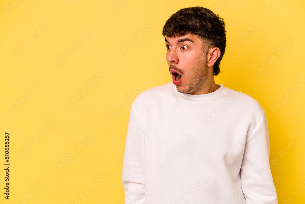 Young caucasian man isolated on yellow background being shocked because of something she has seen. Young caucasian man isolated on yellow background being shocked because of something she has seen.