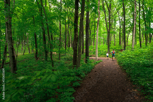 father and son hiking on a trail in the woods at Effigy Mounds in Iowa photo