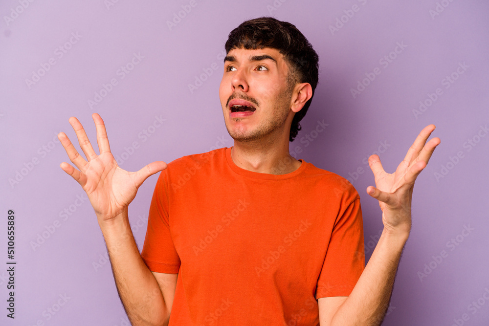 Naklejka premium Young caucasian man isolated on purple background screaming to the sky, looking up, frustrated.