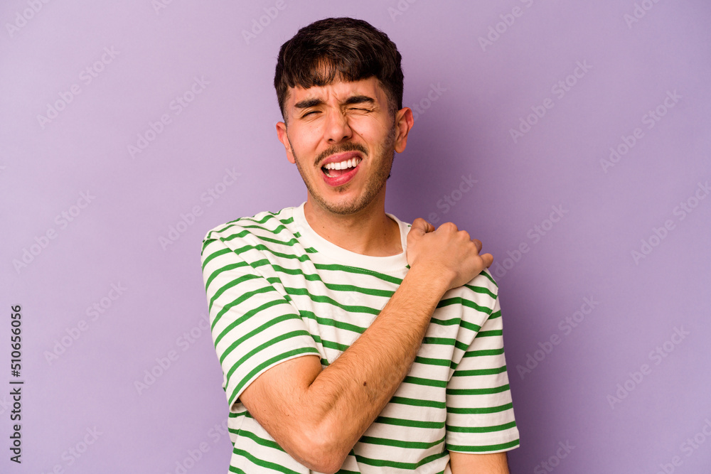 Young caucasian man isolated on purple background having a shoulder pain. Young caucasian man isolated on purple background having a shoulder pain.