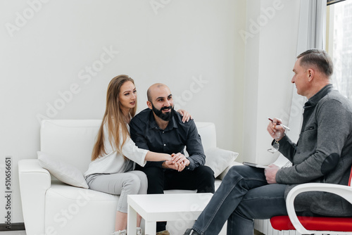 Fototapeta Naklejka Na Ścianę i Meble -  A young married couple came to an appointment and consultation with a psychotherapist. Counseling and help during depression and solving family problems. 