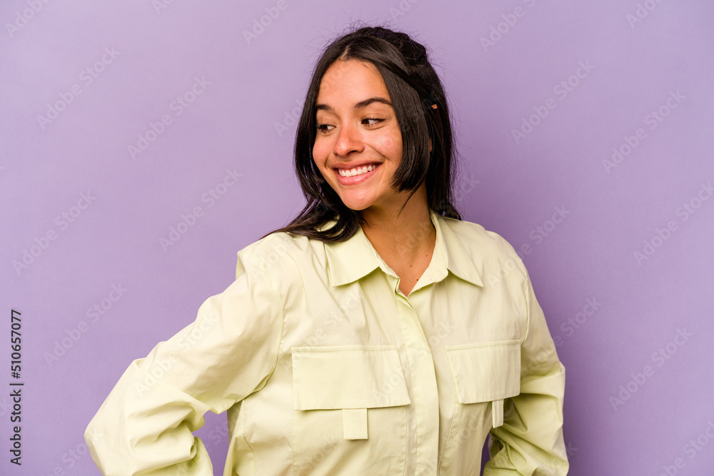 Young hispanic woman isolated on purple background laughs happily and has fun keeping hands on stomach. Young hispanic woman isolated on purple background laughs happily and has fun keeping hands on stomach.