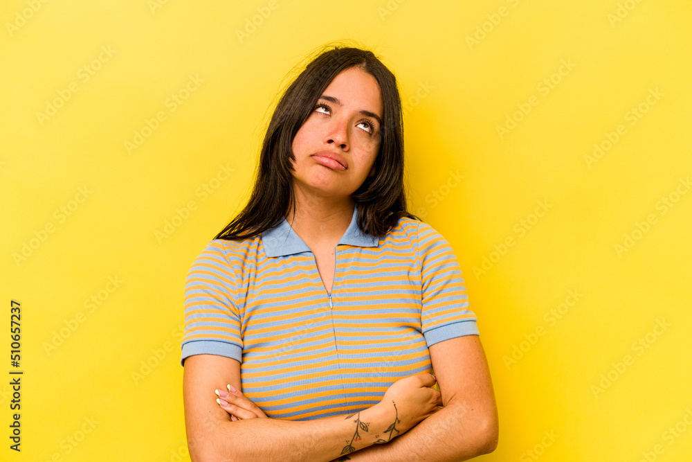 Obraz premium Young hispanic woman isolated on yellow background tired of a repetitive task.