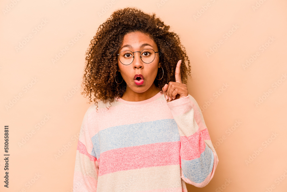 Young African American woman isolated on beige background having an idea, inspiration concept. Young African American woman isolated on beige background having an idea, inspiration concept.