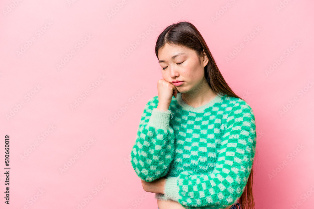 Young Chinese woman isolated on pink background who feels sad and pensive, looking at copy space. Young Chinese woman isolated on pink background who feels sad and pensive, looking at copy space.