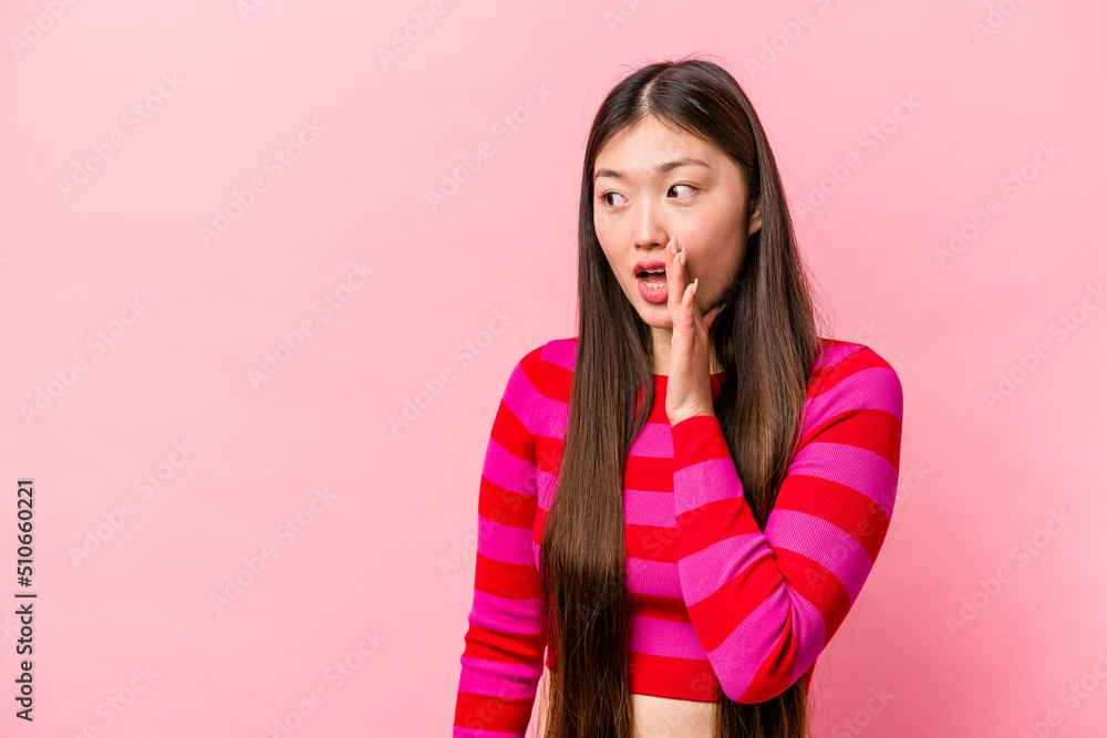 Young Chinese woman isolated on pink background being shocked because of something she has seen. Young Chinese woman isolated on pink background being shocked because of something she has seen.