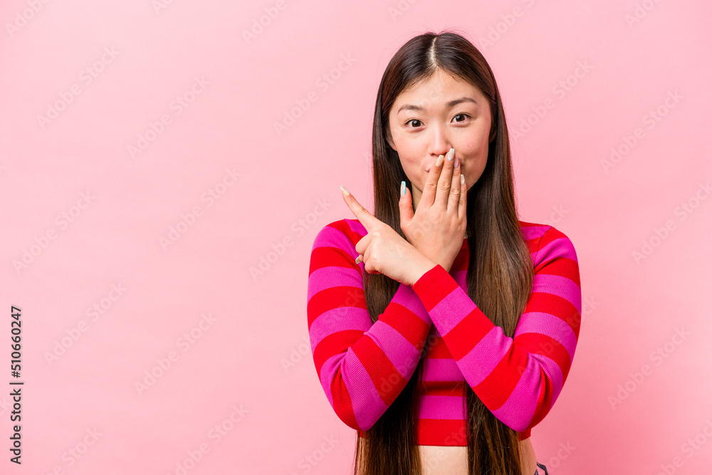 Young Chinese woman isolated on pink background pointing to the side Young Chinese woman isolated on pink background pointing to the side