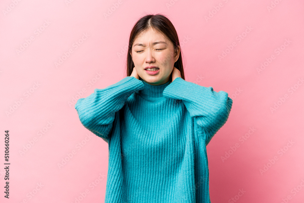 Young Chinese woman isolated on pink background suffering neck pain due to sedentary lifestyle. Young Chinese woman isolated on pink background suffering neck pain due to sedentary lifestyle.