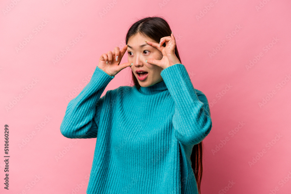 Young Chinese woman isolated on pink background keeping eyes opened to find a success opportunity. Young Chinese woman isolated on pink background keeping eyes opened to find a success opportunity.
