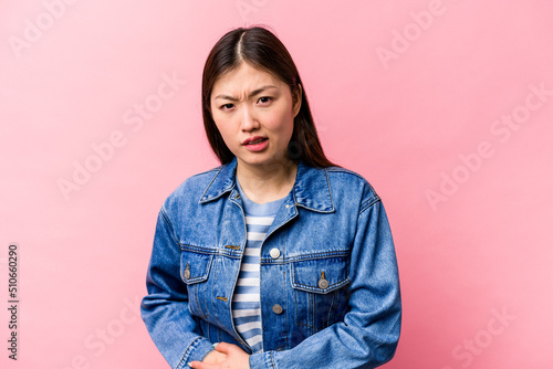 Young Chinese woman isolated on pink background having a liver pain, stomach ache.
