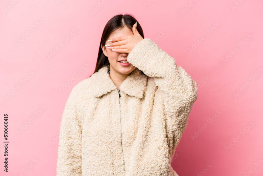 Obraz premium Young Chinese woman isolated on pink background covers eyes with hands, smiles broadly waiting for a surprise.