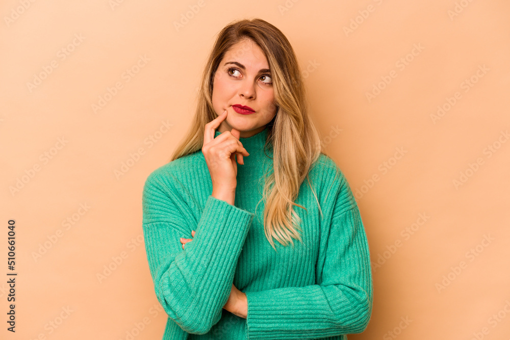 Young caucasian woman isolated on beige background contemplating, planning a strategy, thinking about the way of a business. Young caucasian woman isolated on beige background contemplating, planning a strategy, thinking about the way of a business.