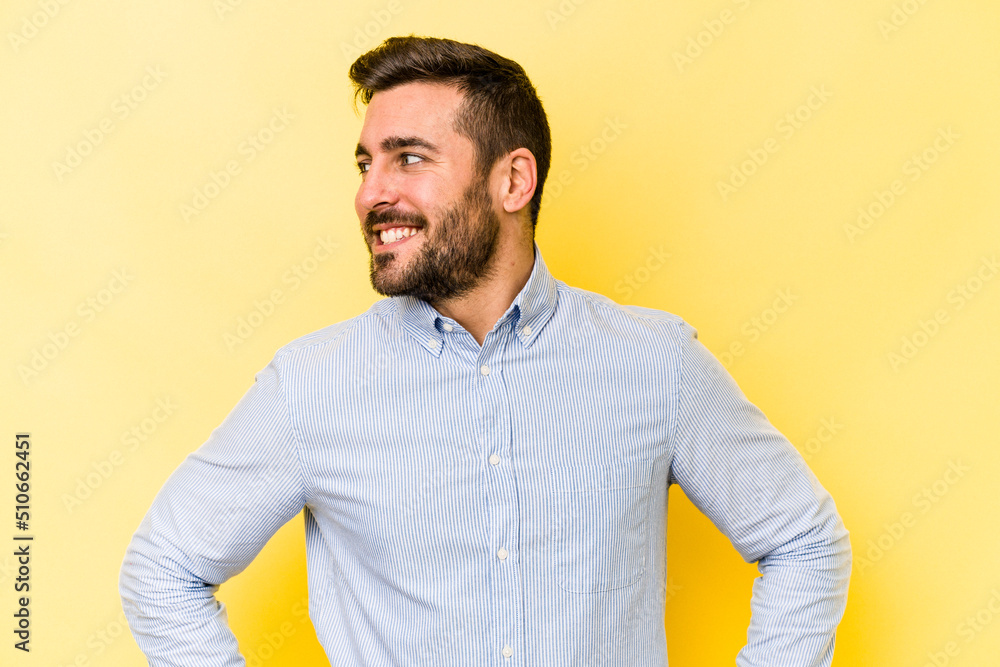 Young caucasian man isolated on yellow background confident keeping hands on hips. Young caucasian man isolated on yellow background confident keeping hands on hips.