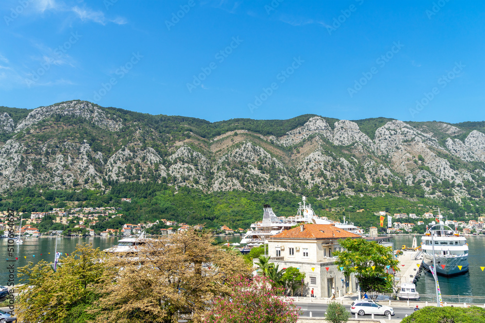 View of yachts, mountains, palm trees, houses and marina in the Bay of Boka Kotor from the side of the city of Kotor. Adriatic Sea