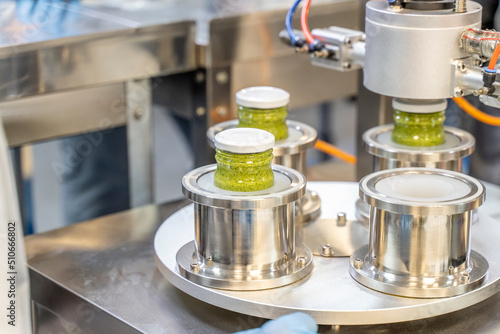 Pesto sauce Industrial process. vacuum sealing machine for canned food. production of Pesto sauce. Vacuum Seamer for Cylindrical Cans of Rotary Type. photo