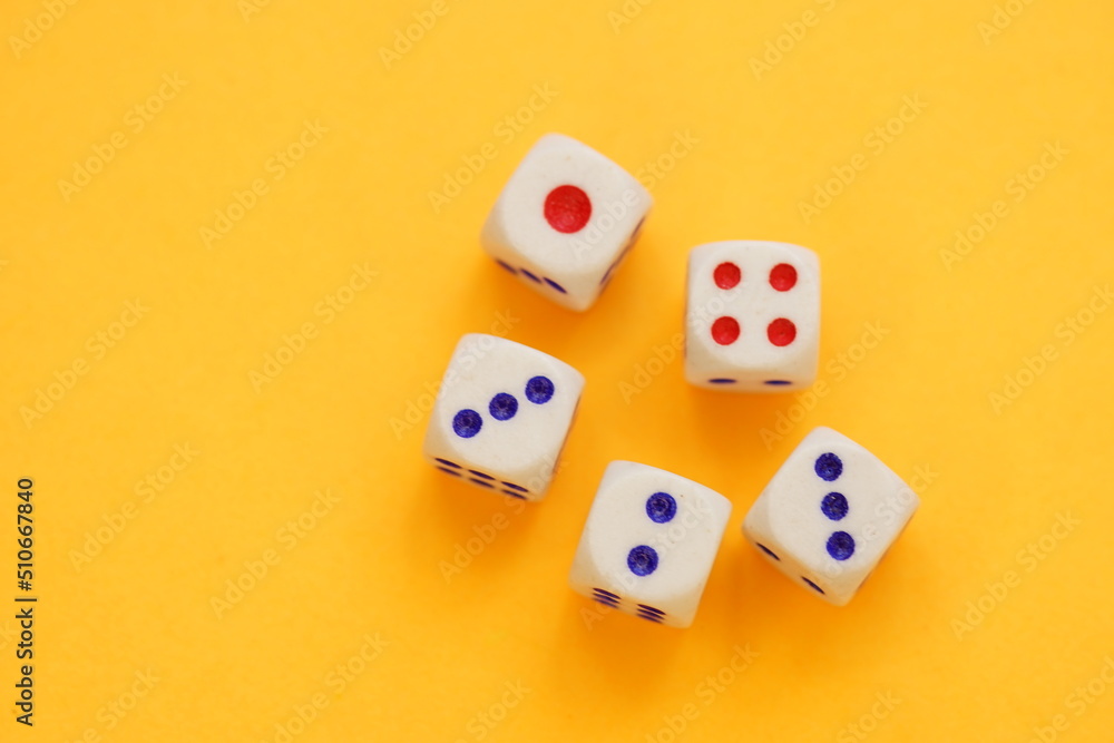 Five dice with different numbers on a orange sunny table Five dice with different numbers on a orange sunny table