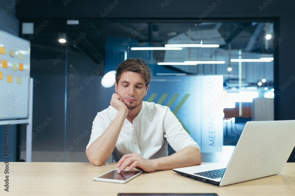 Young man thinking in office, businessman working with laptop on business plan and startup development strategy Young man thinking in office, businessman working with laptop on business plan and startup development strategy