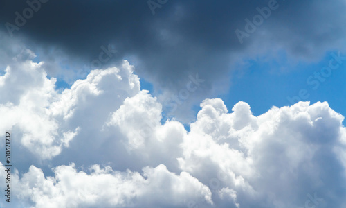 Summer sky. Cumulus clouds on a blue background. Partly cloudy.