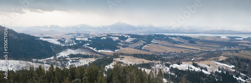 Aerial view on snowy valley with mountain range shrouded in clouds in background, Slovakia, Europe
