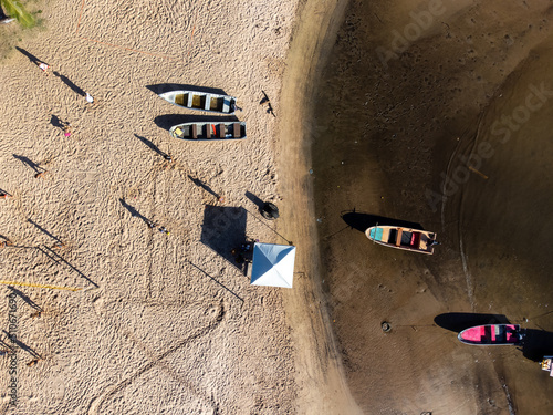 Top drone view of small fishing boats on river beach photo