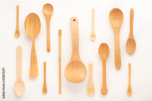 set of empty wooden spoons of different sizes with over white background, trendy flat lay