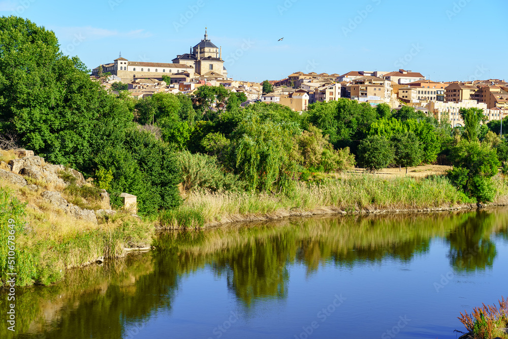 Panoramic view of the city of Toledo along the Tagus River on a sunny day.