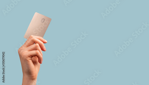 Banner with hand holding credit card mockup with chip on blue background. Buying at stores, making transactions at terminals. Secure payments. High quality photo photo