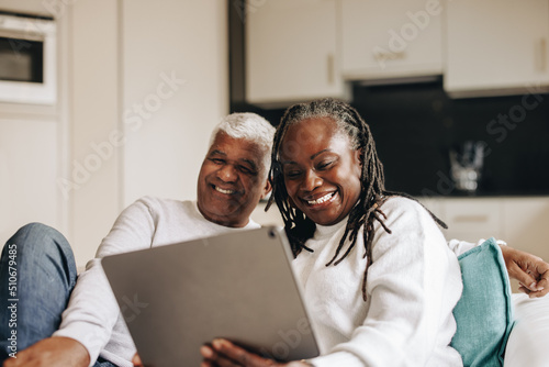 Carefree senior couple having a video call on a digital tablet