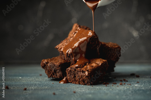 Cuadro en lienzo Pieces of chocolate biscuit brownie covered with melted dark chocolate on the bl