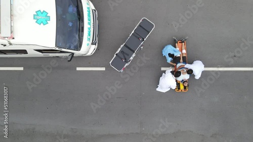 Top view emergency team use stretcher cot to transport or move patient into ambulance after he hurt by some accident on road.