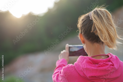 Woman taking photo of a sunrise
